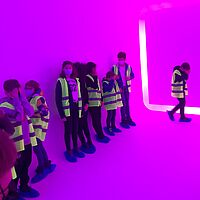 Kinder vor pinker leuchtender Wand