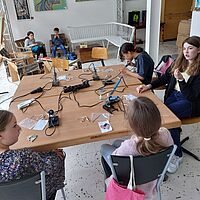 Mädchen lernen die Tiffany Technik kennen und gestalten damit Herzanhänger