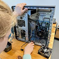 Kind nimmt ein altes Elektrogerät auseinander